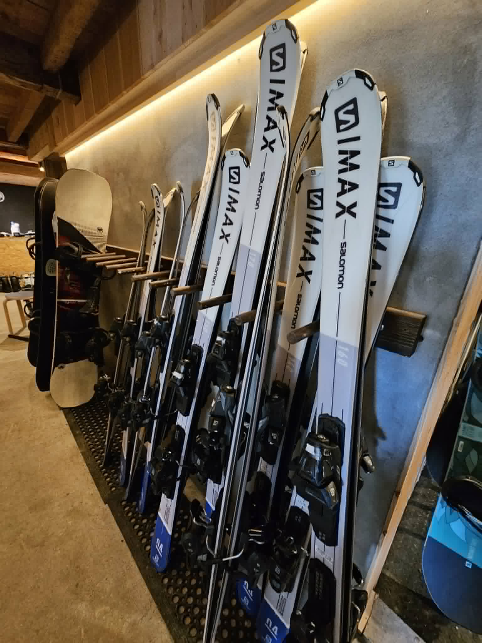 Salomon rental skis and a snowboard racked at Escape Myoko's ski shop in Myoko Kogen
